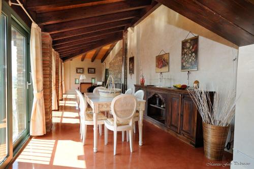 a kitchen with a dining room table and chairs at Relais La Colombara Spa & Wellness in Travo
