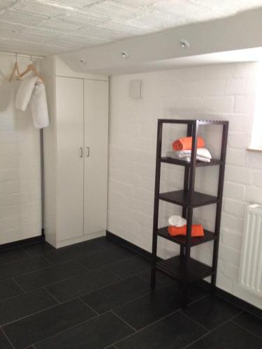 a room with white walls and a shelf with pillows at Ruhige 1 Zimmerwohnung Souterrain in Bortfeld