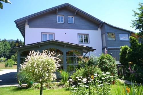 a large white house with a porch at Erlebnispension Zum Wanderer Sepp in Arnbruck