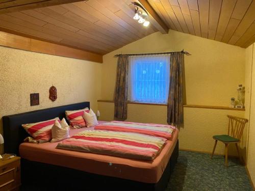 a bedroom with a large bed with a window at Erlebnispension Zum Wanderer Sepp in Arnbruck