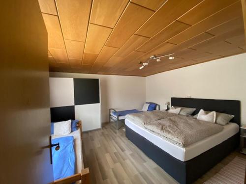 a bedroom with a large bed and a wooden ceiling at Erlebnispension Zum Wanderer Sepp in Arnbruck