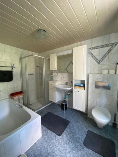a bathroom with a tub and a toilet and a sink at Erlebnispension Zum Wanderer Sepp in Arnbruck