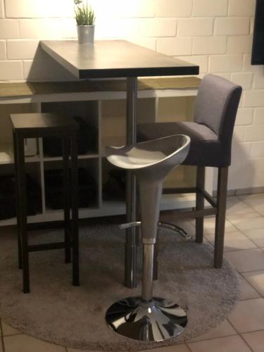 a desk with a chair and a table with a stool at Ruhige 1 Zimmerwohnung Souterrain in Bortfeld