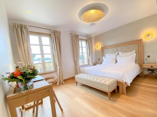 a bedroom with a large white bed and a table at Petit Monlot - Saint-Emilion in Saint-Émilion