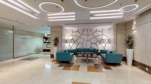a lobby with two blue chairs and a table at Ayass Hotel in Amman