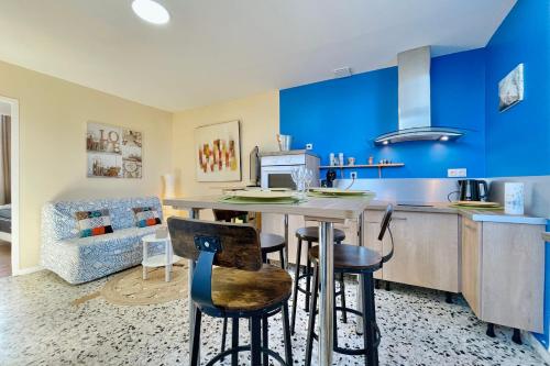 a kitchen with blue walls and a table and chairs at The City in the Country #CB in Gières