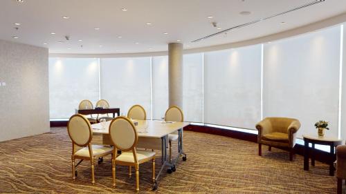 a conference room with tables and chairs and large windows at Ayass Hotel in Amman