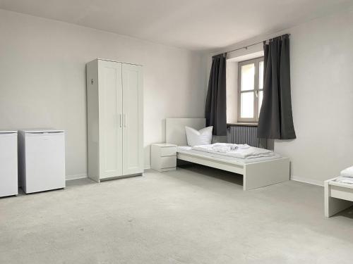 Una habitación blanca con una cama y una ventana. en SAD181 - Zentrale Monteurwohnung, en Schwandorf