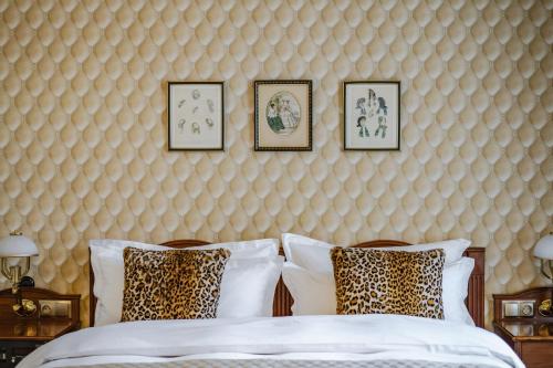 a bedroom with two beds and framed pictures on the wall at Hotel H15 Francuski Old Town - Destigo Hotels in Kraków