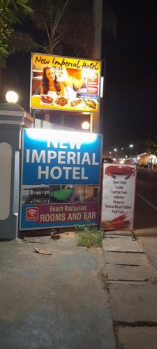 una señal para un hotel imperial en una calle por la noche en New Imperial Hotel, en Hikkaduwa