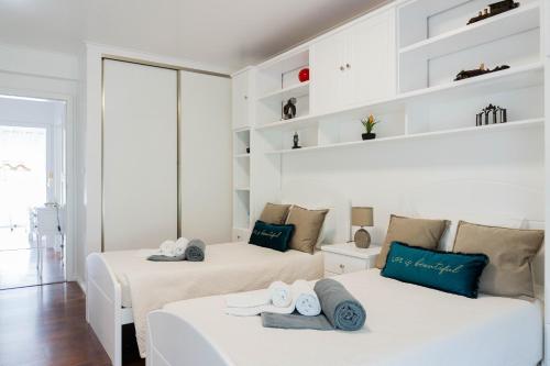 Dos camas en una habitación blanca con toallas. en Bela Vista, en Ponta Delgada