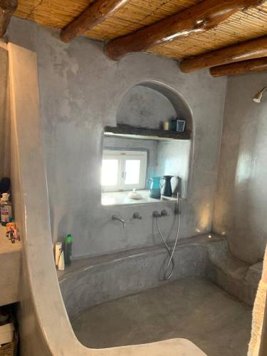 a bathroom with a bath tub with a window at Lydia's house in Révmata