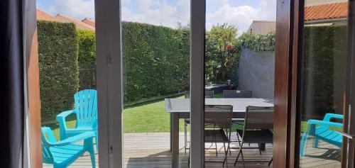 a patio with a table and chairs on a deck at Maison avec piscine commune à 800m de la plage in Brem-Sur-Mer