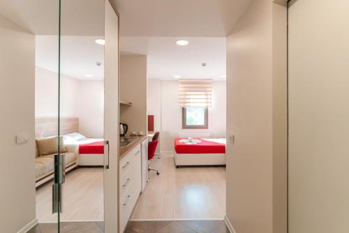 a bedroom with two beds and a desk and a mirror at Ucar Royal Hotel ve Konferans Salonu in Sile