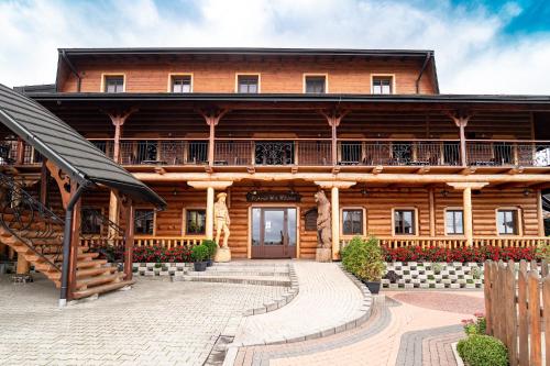 a large wooden house with a staircase leading up to it at Zajazd Chyżne in Chyżne