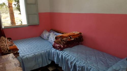 a bed in a room with a red wall at Hôtel Glacier in Fez