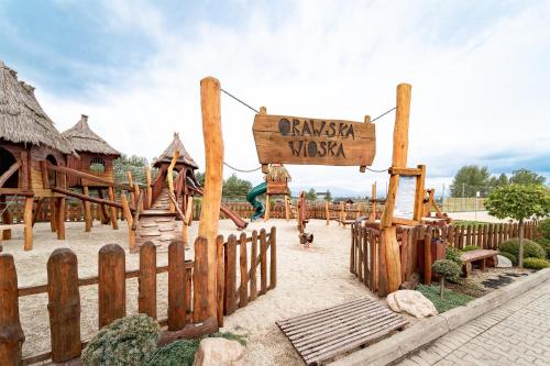 a playground in a park with a wooden fence at Zajazd Chyżne in Chyżne