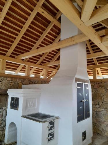 a room with a stove and a wooden ceiling at Tiszafa Vendégház Szentgál in Szentgál