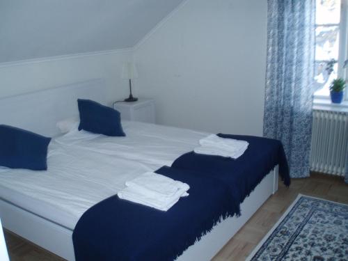 a bedroom with two beds with blue and white sheets at Åkerby Herrgård in Nora
