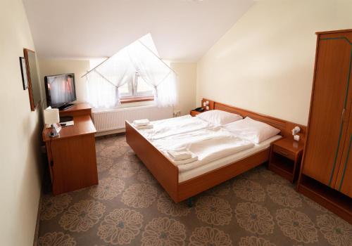 a hotel room with a bed and a television at Zajazd Chyżne in Chyżne
