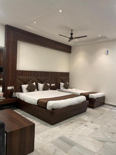 a bedroom with two beds and a ceiling at Hotel Royal Embassy in Tinsukia