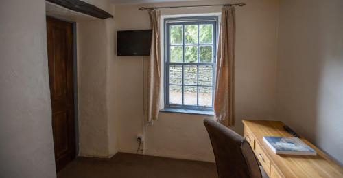a room with a wooden table and a window at Badger Bar in Ambleside
