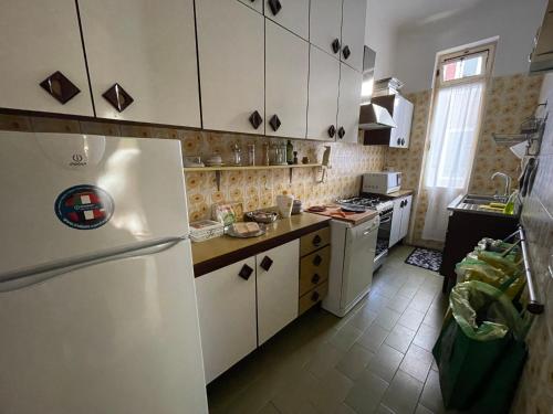 una cucina con armadietti bianchi e frigorifero bianco di Ca Savelli a Venezia