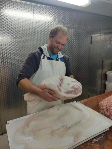 a man in a kitchen holding a large loaf of bread at Tourist farm Pri Andrejevih in Narin