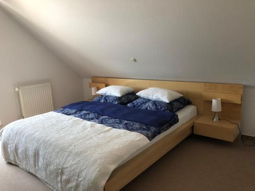 Schlafzimmer mit einem großen Bett mit blauer und weißer Bettwäsche in der Unterkunft Charmante 2-Zimmer Wohnung in Hoisdorf