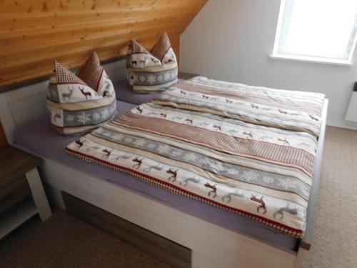 a bed with two pillows on top of it at Haus Eugen in Presseck
