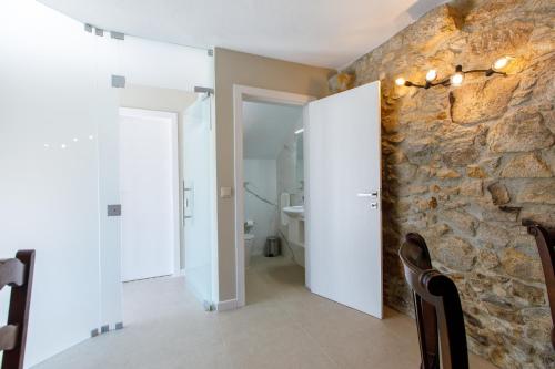 Habitación con pared de piedra y baño. en Quinta dos Fangueiros, en Riba de Âncora