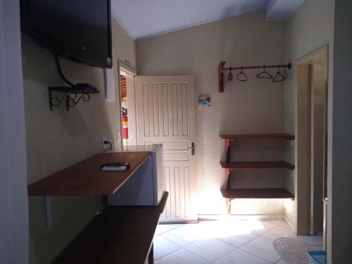 une cuisine avec un comptoir, une porte et un escalier dans l'établissement Canto Sul Suítes, à Ubatuba