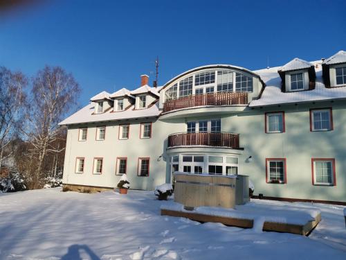 a large white building with snow on the ground at Penzion Pastviny in Pastviny
