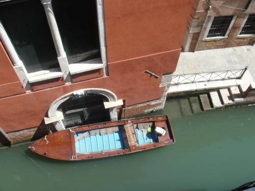 an old boat in the water next to a building at Palazzetto San Lio, Rialto in Venice