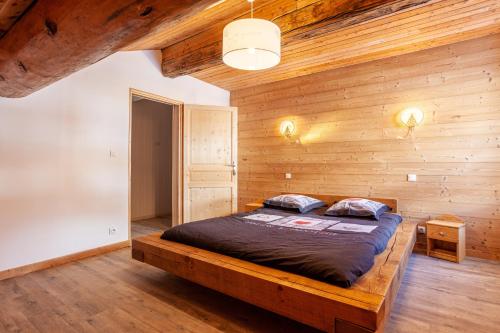 a bedroom with wooden walls and a large bed at La Réchasse in Termignon