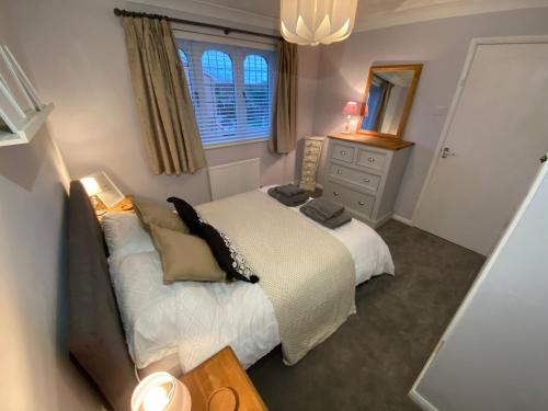 a bedroom with a bed and a dresser and a mirror at Lovely family home, 5 minutes from the beach in Clacton-on-Sea