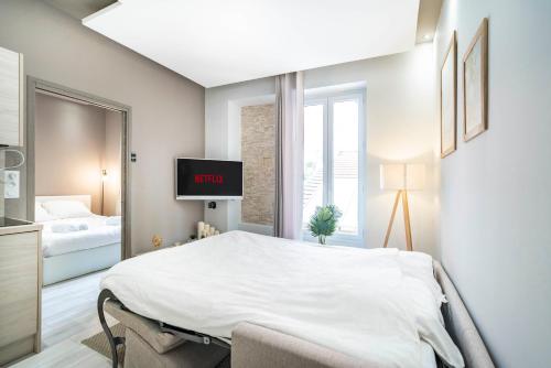 a bedroom with a bed and a tv in it at Frontière Monaco - Appartement moderne rénové - AH in Beausoleil