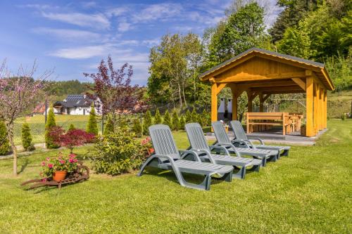 a group of chairs in a garden with a gazebo at DOMKI POD ZIELONYM WZGÓRZEM in Kudowa-Zdrój