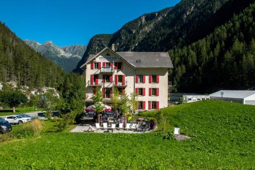 una grande casa su una collina con un campo verde di Auberge du Mont Blanc a Trient