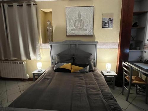 a bedroom with a large bed with two lamps on it at LE PETIT ZEN in Froberville