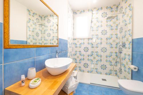 y baño con lavabo, bañera y espejo. en TaoApartments - Casa Salina, en Taormina