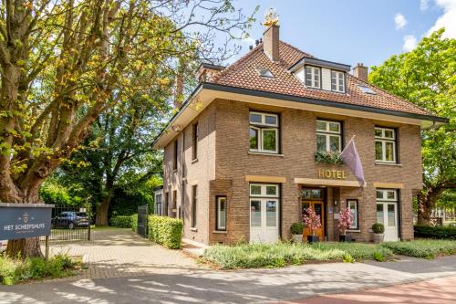 un grand bâtiment en briques avec un hôtel dans une rue dans l'établissement Boutique Hotel Het Scheepshuys, à Breda