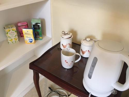 a table with two coffee cups and a blender at Chalkcroft lodge in Andover