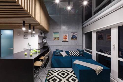 a living room with a blue couch and a table at Hiport Apart Hotel in Dnipro