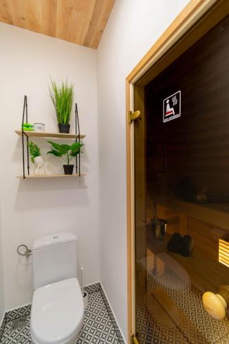 a bathroom with a toilet and a sign on the door at Apartments24 Spordi in Rakvere