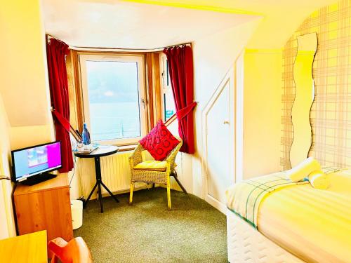 ein Schlafzimmer mit einem Bett, einem Stuhl und einem Fenster in der Unterkunft Rowantreebank Bed and Breakfast in Arrochar