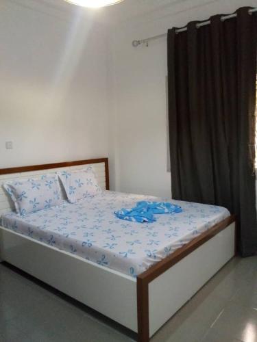 a bedroom with a bed with blue flowers on it at Your home II in Yaoundé