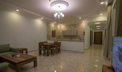 a living room with a table and a kitchen at منتجع فيوري - الهدا in Taif