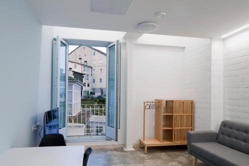 a living room with a large glass door to a balcony at Apartamentos Turísticos As Burgas 6 by Bossh Hotels in Ourense