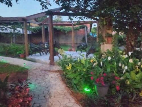 a garden with a pergola and some flowers at Pousada Veadeiros - Alto Paraiso de Goiás in Alto Paraíso de Goiás